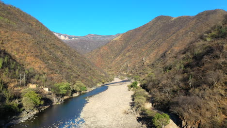 stream running through landscap of copper canyon, mexico, forward aerial