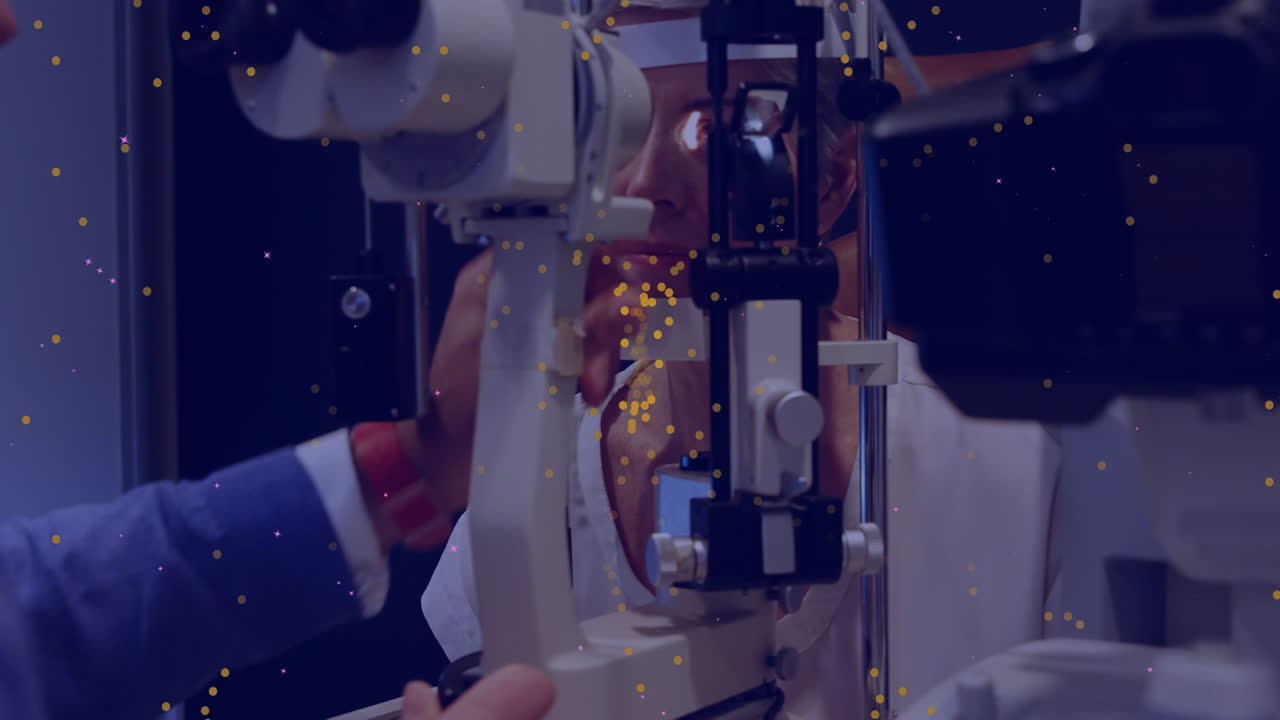 Animation of yellow dots moving over caucasian male eye doctor testing patient