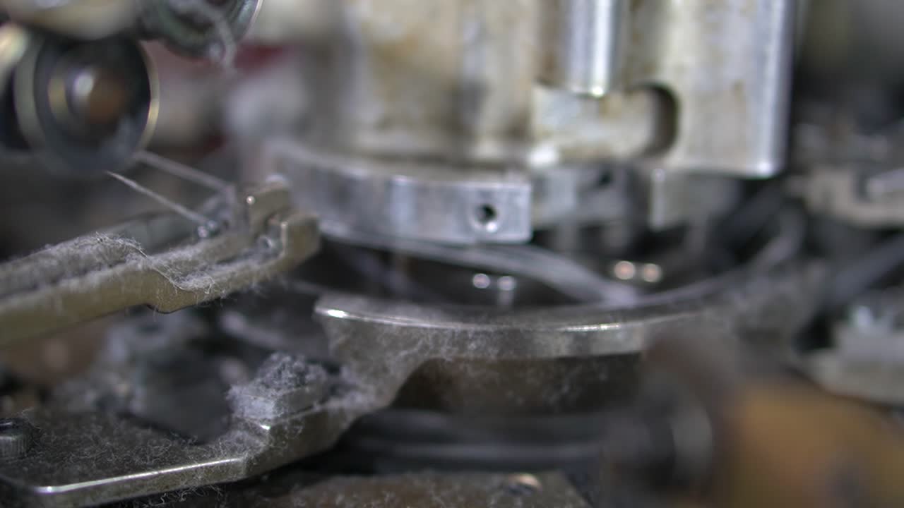 Close-up parts of the machine with threads, the Production process in a garment factory, automated process, manufacture of socks