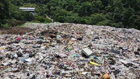 Drone-dolly-shot-of-a-waste-management-center-and-land-fill-on-a-tropical-Island