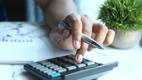 person using a calculator and pen