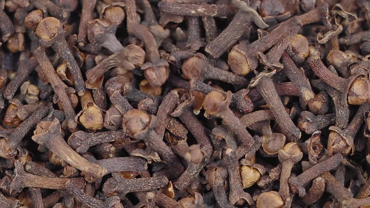 Cravos-da-índia Secos Inteiros Caindo sobre uma Pilha de Especiarias