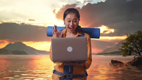 mujer emocionada con una computadora portátil en un pintoresco lago al atardecer