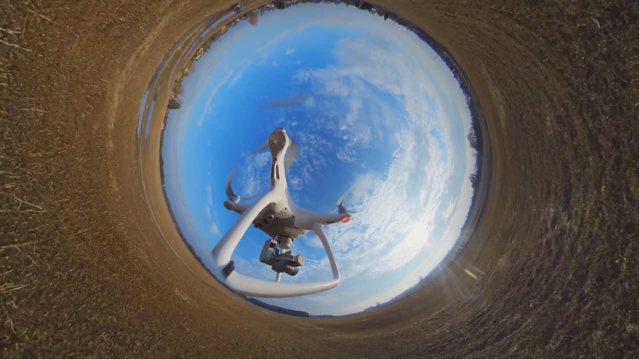 vista lateral de primer plano del dron quadcopter dji phantom 4 volando hacia atrás sobre los campos