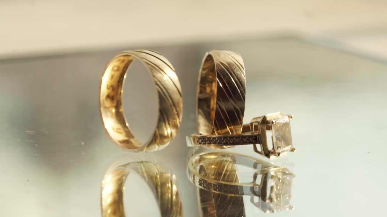 Three golden rings moving, turns and spin on a mirror surface