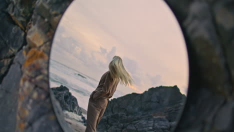 girl stepping evening beach in mirror reflection. carefree sexy blonde spinning