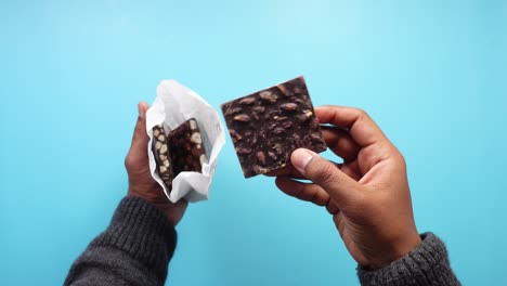 person holding and unwrapping chocolate bar