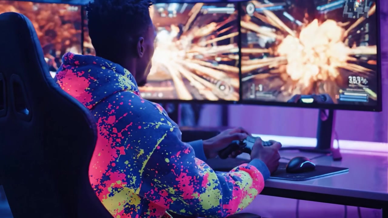 Intensive Gaming-Session: Ein leidenschaftlicher Spieler vertieft in einem hell beleuchteten Raum mit zwei Monitoren, die rasante Gameplay-Action zeigen.