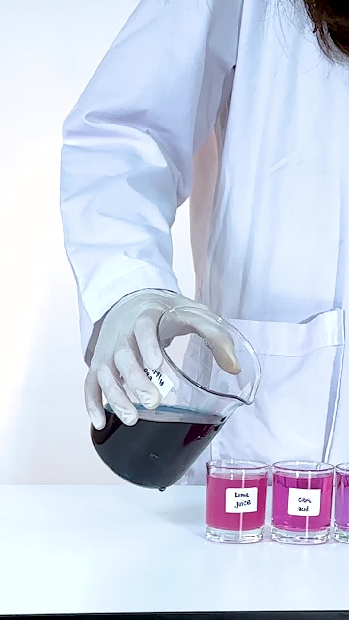 Scientist pours liquid into test tubes, observing color changes. Bright lighting highlights the chemical reaction process