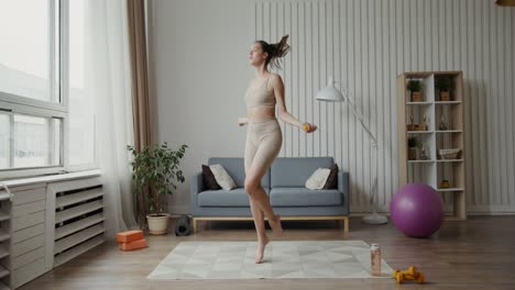 mujer saltando la cuerda y trabajando en su sala de estar