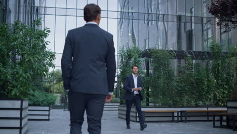 confident managers walking business center green garden. businesspeople concept