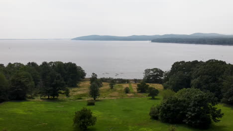 slow drone descent showing lake with kayaks, then to reveal a burnt out buildings in the foreground