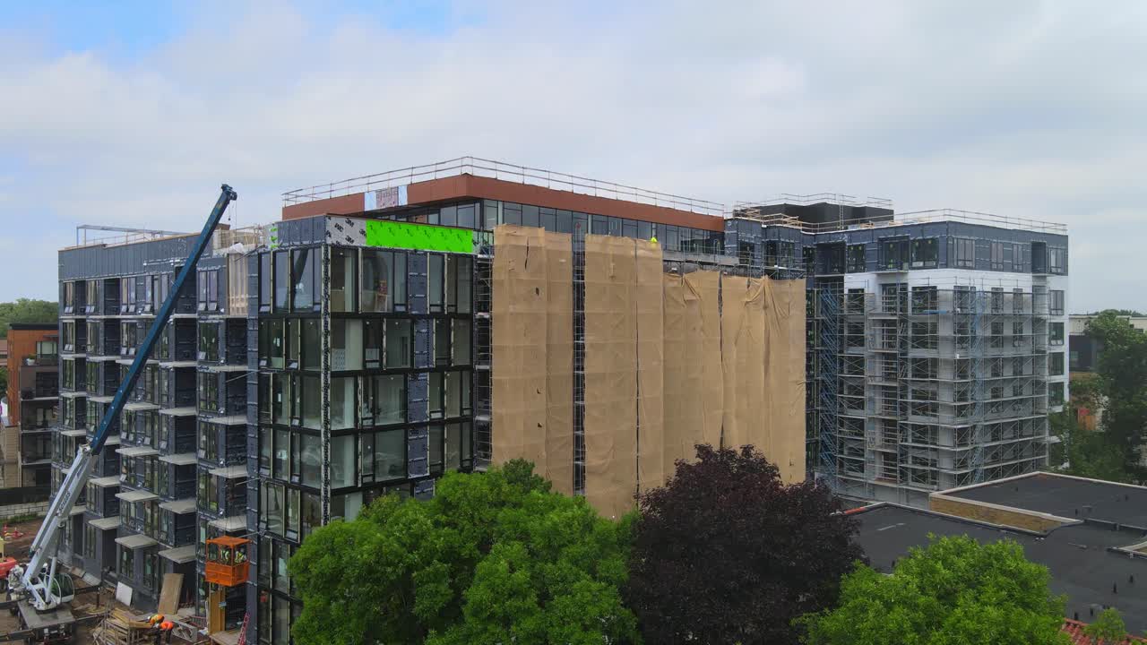 vista aérea del exterior de un edificio en construcción, ventanas y balcones instalados