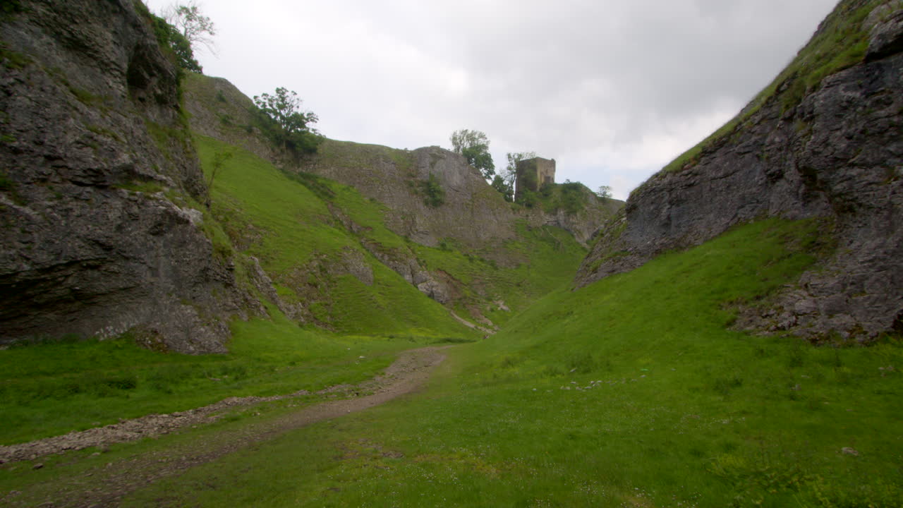 Scenic view of a green valley with a path leading to castle ruins