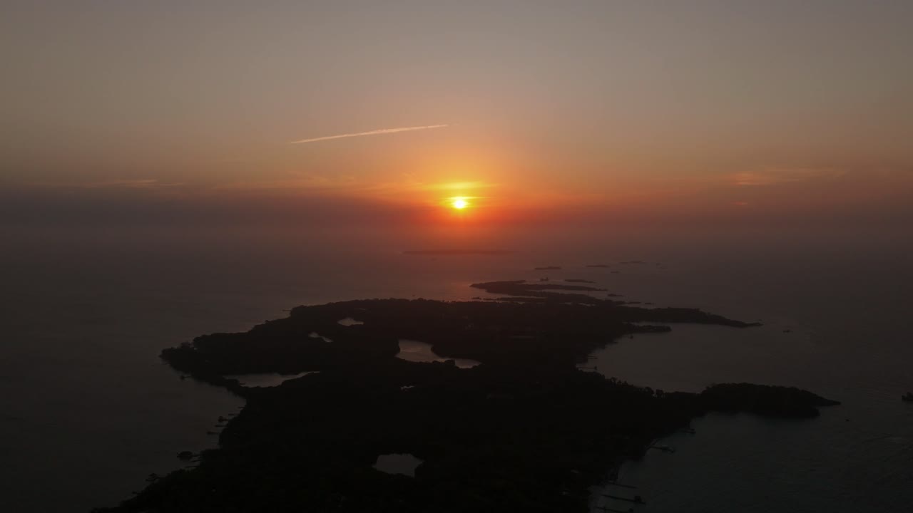Drone view of Isla Grande in Rosario Islands during a sunset, Colombia, surrounded by crystal clear Caribbean waters, coral reefs and lush tropical scenery