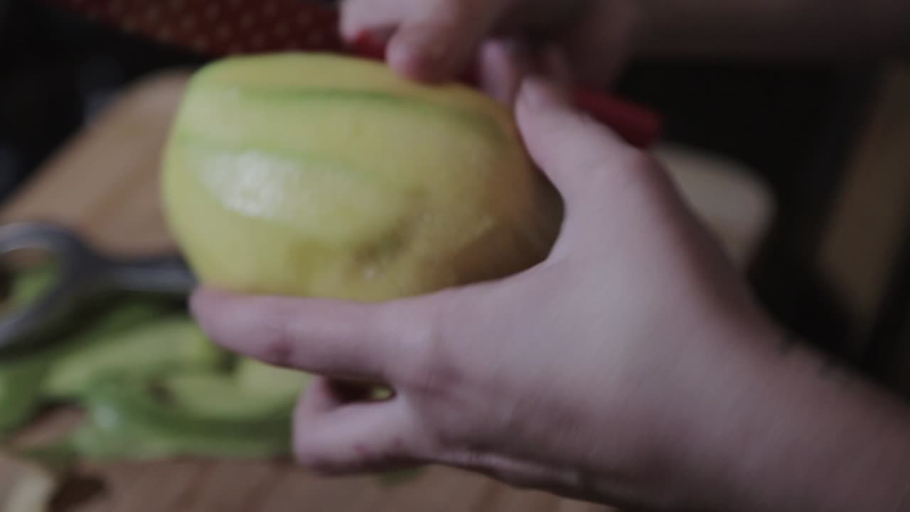 Sbucciare un mango verde fresco usando un coltello affilato - Primo piano