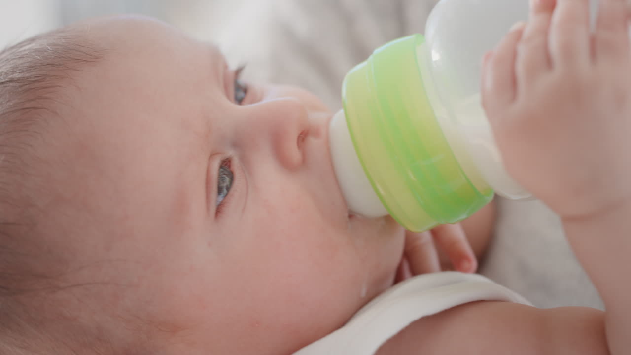 madre alimentando al bebé bebiendo de la botella de leche madre amorosa cuidando del bebé en casa responsabilidad de la maternidad 4k