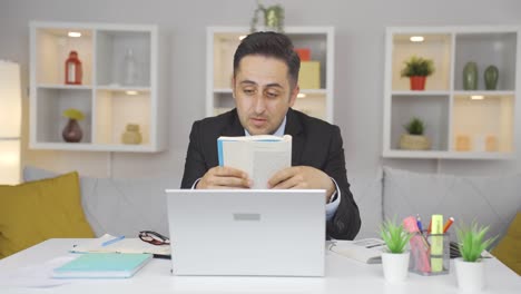 Hombre-Trabajador-De-Oficina-En-Casa-Leyendo-Un-Libro.