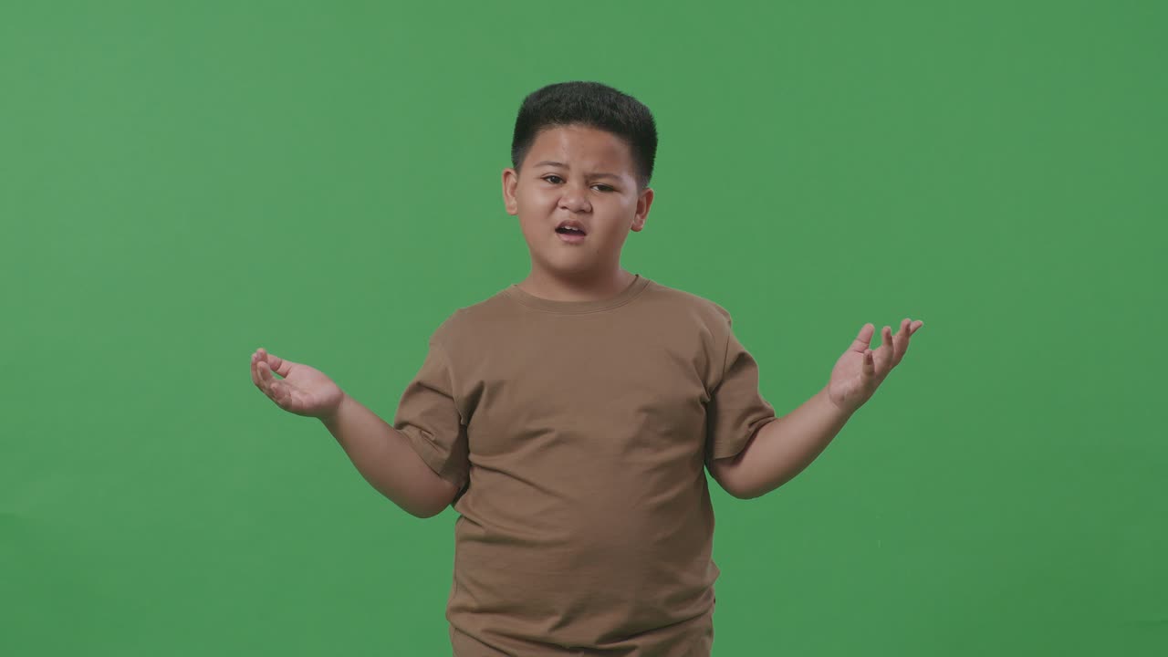 "아시안 소년은 ""왜 녹색 스크린 배경 스튜디오에서 의심스럽게 일하는가?""라고 물었다."