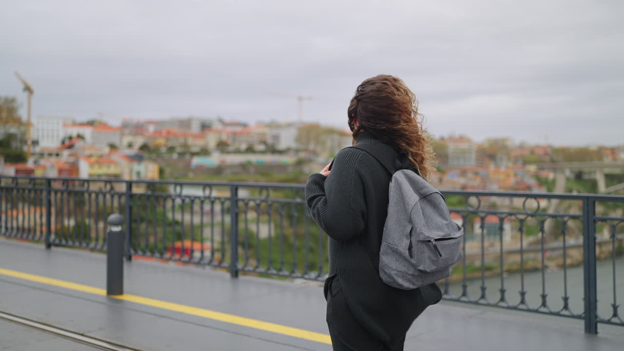 Woman Walking on a City Bridge