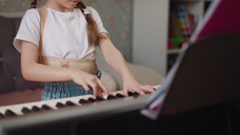 girl plays piano and frowns looking at sheet music intently