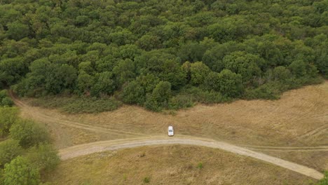 white vehicle positioned on a mountain forest landscape during daylight near mtskheta, georgia