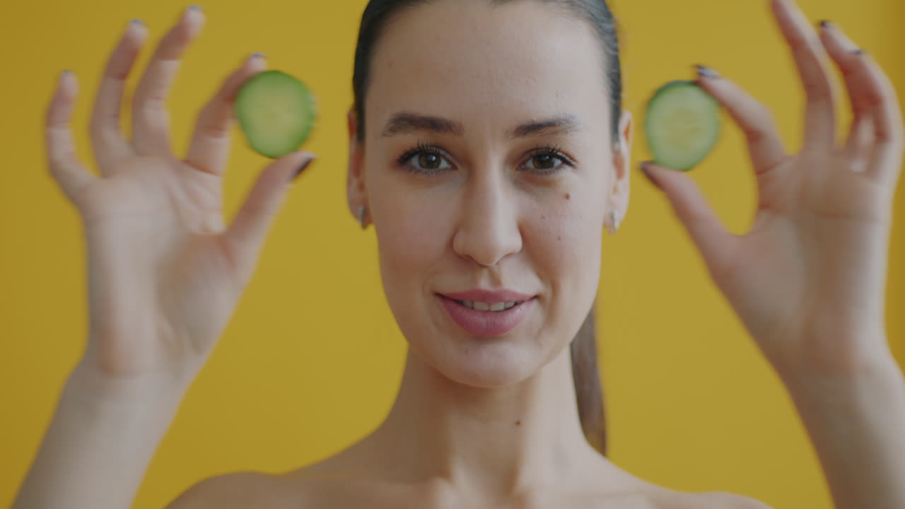Woman with cucumber slices on eyes and smiling