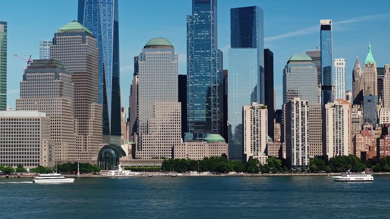 Veleiro flutua enquanto balsa desce pelo rio Hudson com uma revelação aérea épica de edifícios icônicos de arranha-céus de Nova York.