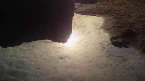 sunset reflection through rocky shore of holywell bay near newquay in cornwall, england. close up