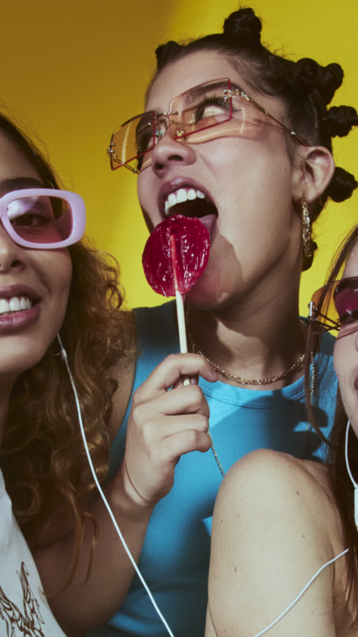 Three young women in sunglasses with a lollipop promoting a special offer