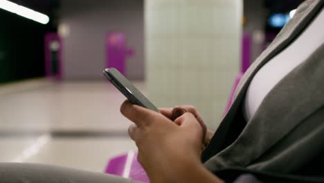 woman using smartphone in a subway station