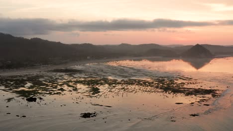 The-dry-reef-of-Kuta-Lombok-during-sunrise,-with-local-people-looking-for-food-and-seashells