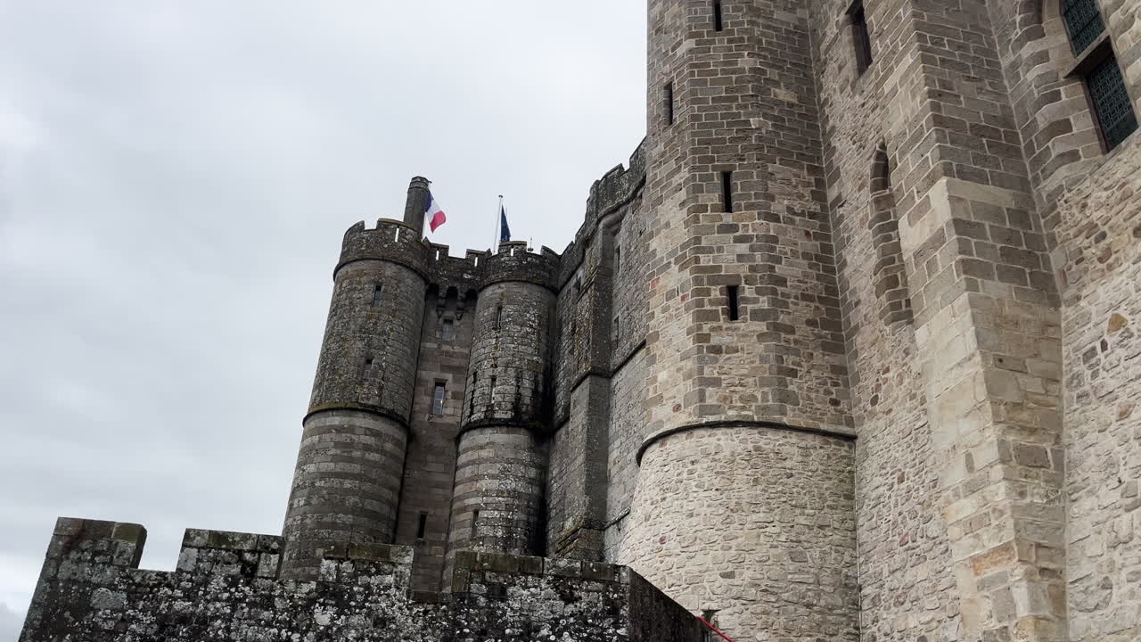 The stunning Saint Michel castle in France, showcasing its towering stone walls and flags