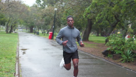 man running in a park on a rainy day