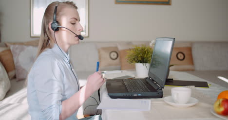 representante de ventas en auriculares hablando con el cliente y haciendo una llamada de videoconferencia en la computadora portátil 2