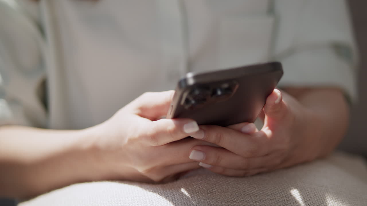 A person interacts with their smartphone while relaxing highlighting modern lifestyle and technology's impact.