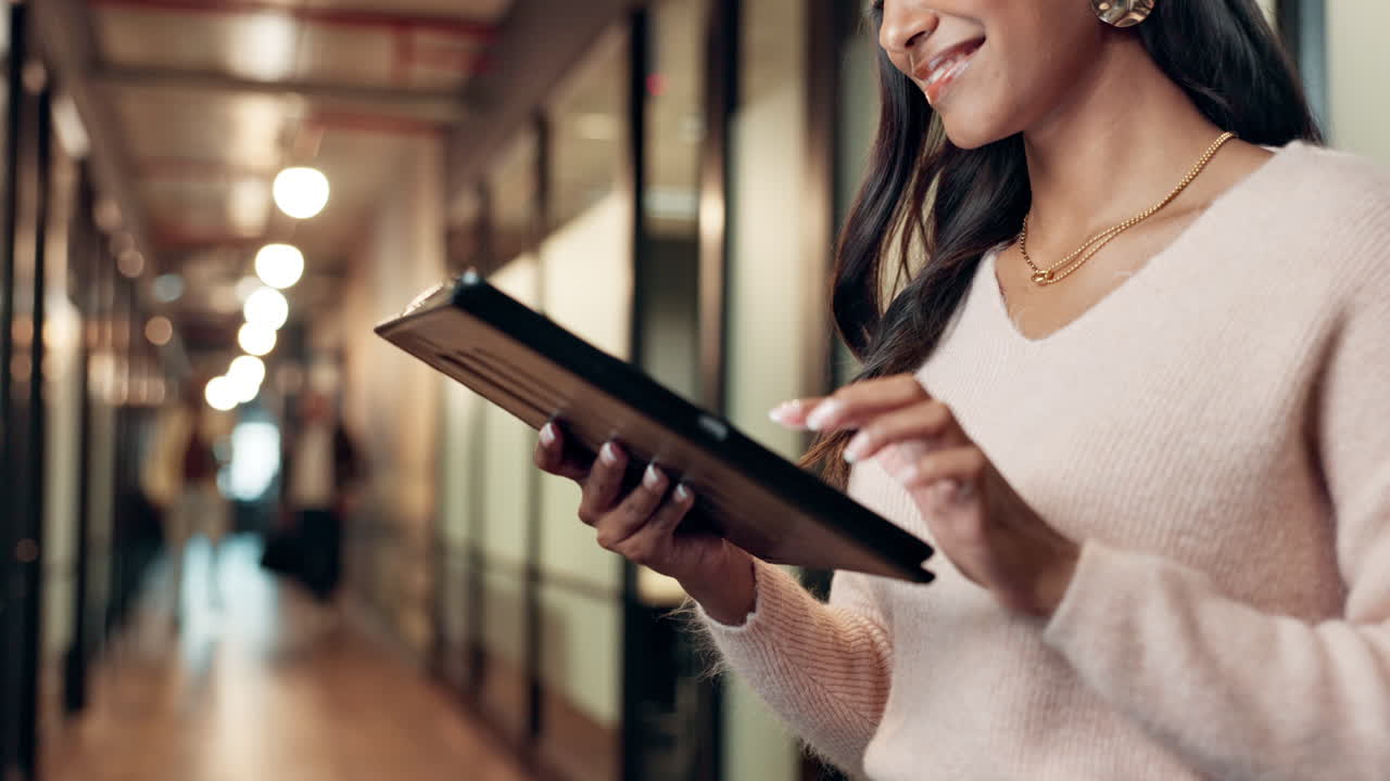 Woman using a tablet in an office hallway
