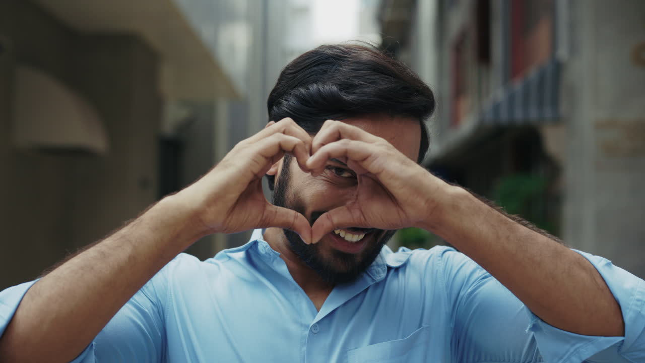 hombre haciendo forma de corazón con las manos