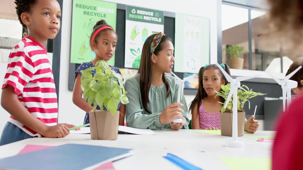 In school, teacher discussing wind energy with students using wind turbine models