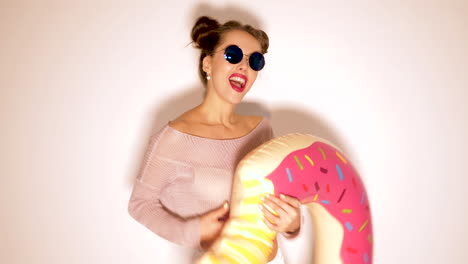 woman with donut pool float and sunglasses