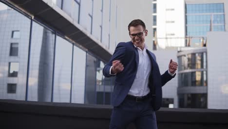 front view of young businessman looking around to sure no one see him and starts to express his feeling about victory and big