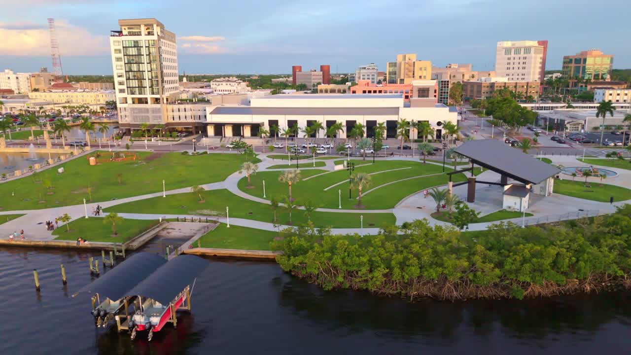 Aerial view of Caloosa Sound Amphitheater and park at shore promenade of fort Myers, Florida. Sunset time in tropical town of USA. Wide shot. Orbit. Quiet atmosphere