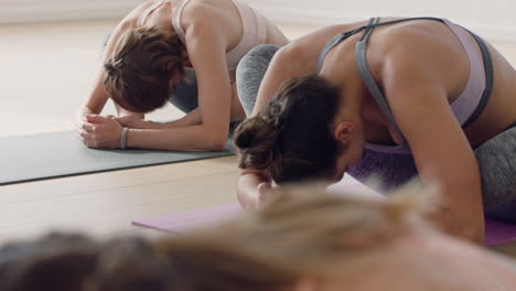 Clase-De-Yoga-Hermosas-Mujeres-Caucásicas-Practicando-Poses-Estirando-El-Cuerpo-Disfrutando-De-Un-Estilo-De-Vida-Saludable-Haciendo-Ejercicio-En-El-Gimnasio-Meditación-Grupal