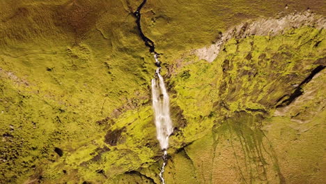 aerial view of waterfall in mountainous terrain