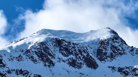 Nubes-Que-Se-Mueven-Rápidamente-En-La-Cima-De-Montañas-Nevadas-Tomadas-Con-Lentes-Telescópicas-De-Drones,-Sin-Clasificar