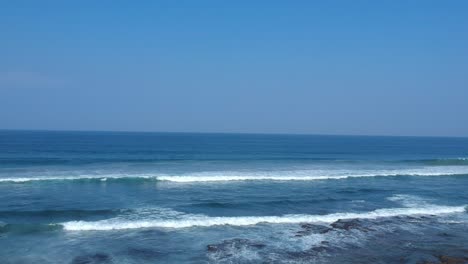 Aerial-footage-filmed-with-a-drone-overlooking-the-beach-and-sea-of-crashing-waves-with-a-deep-blue-ocean-on-the-Bluff-in-Africa-southern-hemisphere