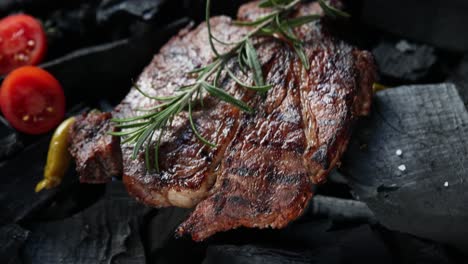 grilled steak with rosemary and vegetables on charcoal