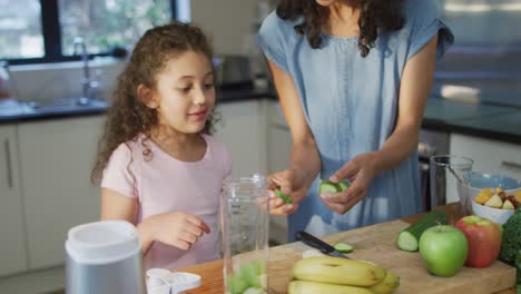 madre e hija de raza mixta cocinando juntos en la cocina