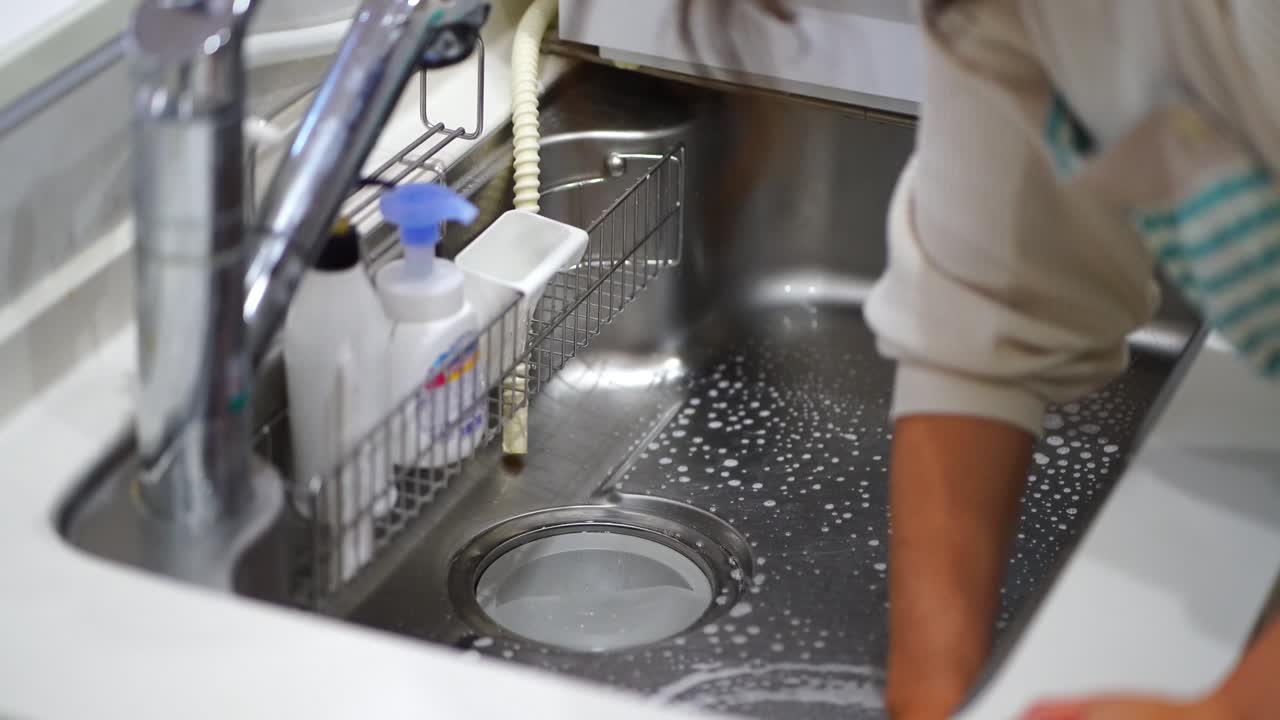 mujer limpiando el fregadero