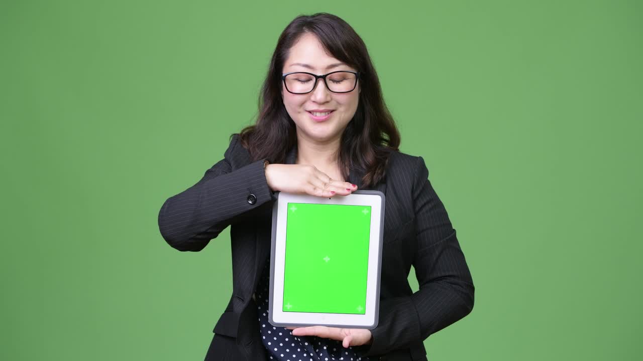 성숙한 아름다운 아시아 사업가 여성이 디지털 태블릿을 보여주고 있습니다.